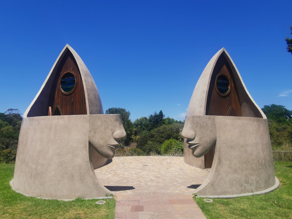 Public toilets in matakana new zealand shaped like boats and the entrance is shaped like faces