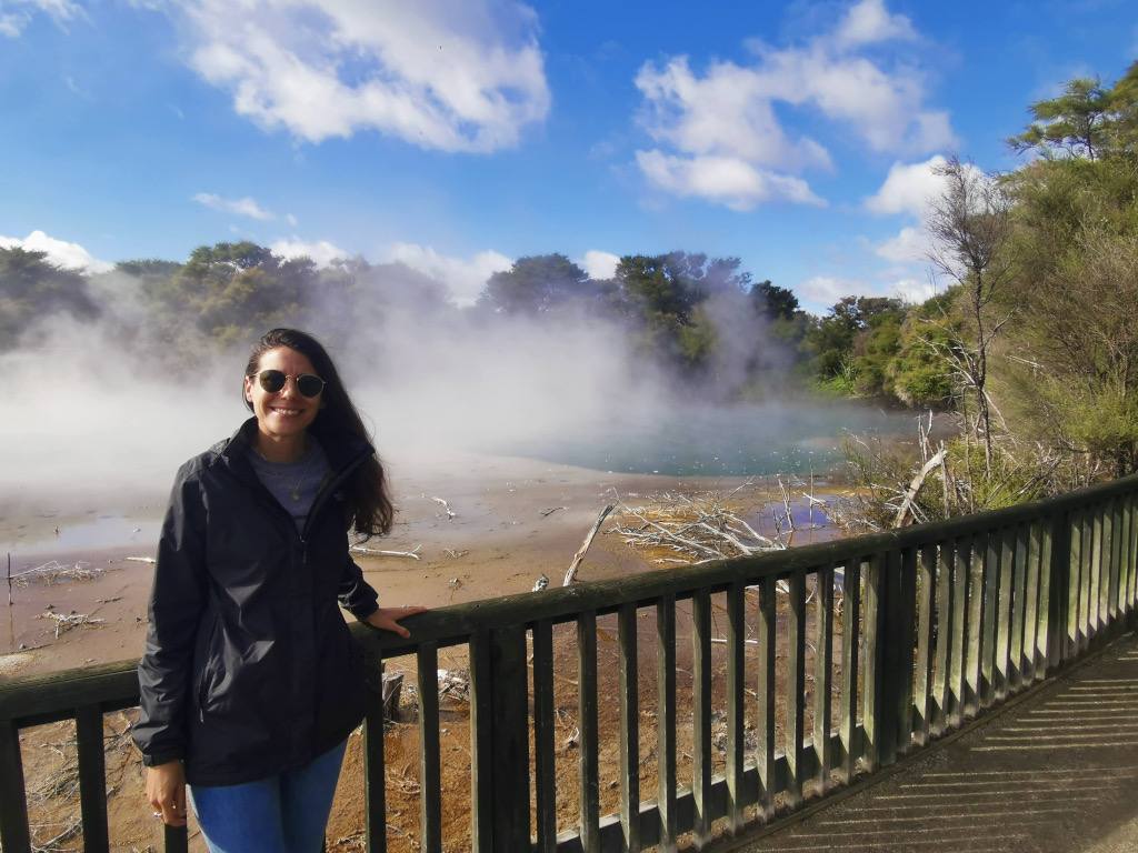 A woman standing in front of a hot spring in Kuira Park one of the best things to din in one day in rotorua