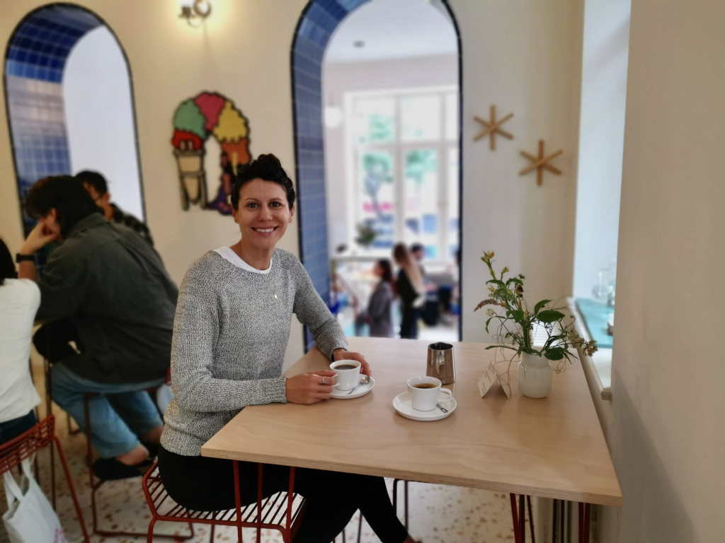 A woman sitting at a table at One Sip Cafe which is one of the best coffee places in Prague