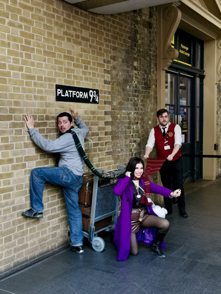 Some tourists taking a photo at the harry potter platform at waterloo station in London