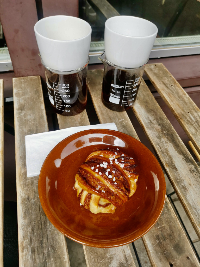 A croissant on a plate next to two cups of coffee at one of the best cafes in amsterdam 4850