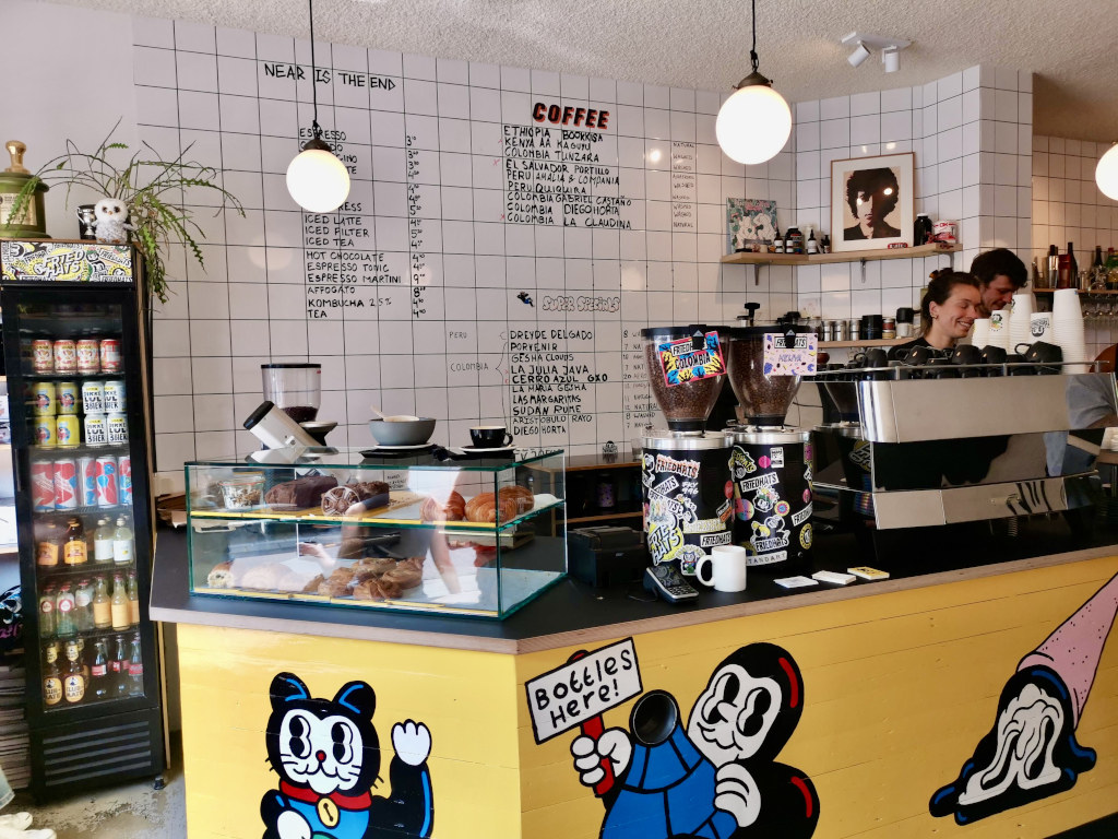 The counter of friedhats fuku cafe with the menu written on the wall with black marker pen