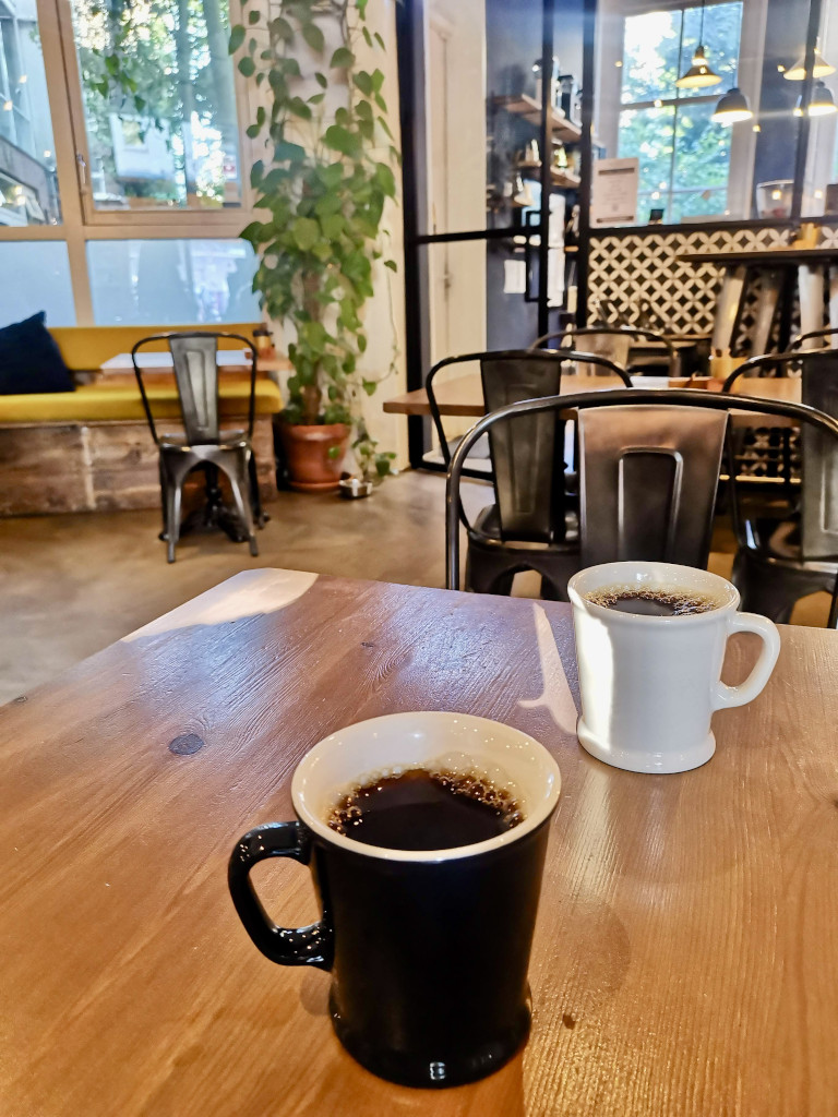 Two cups of coffee sitting on a table at monks coffee roasters one of the best cafes in amsterdam