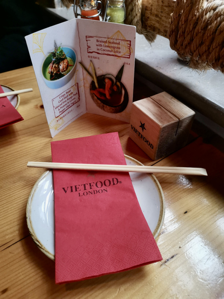 Choptsticks sitting on a plate on top of a red napkin at a vietnamese restaurant in Londons Chinatown