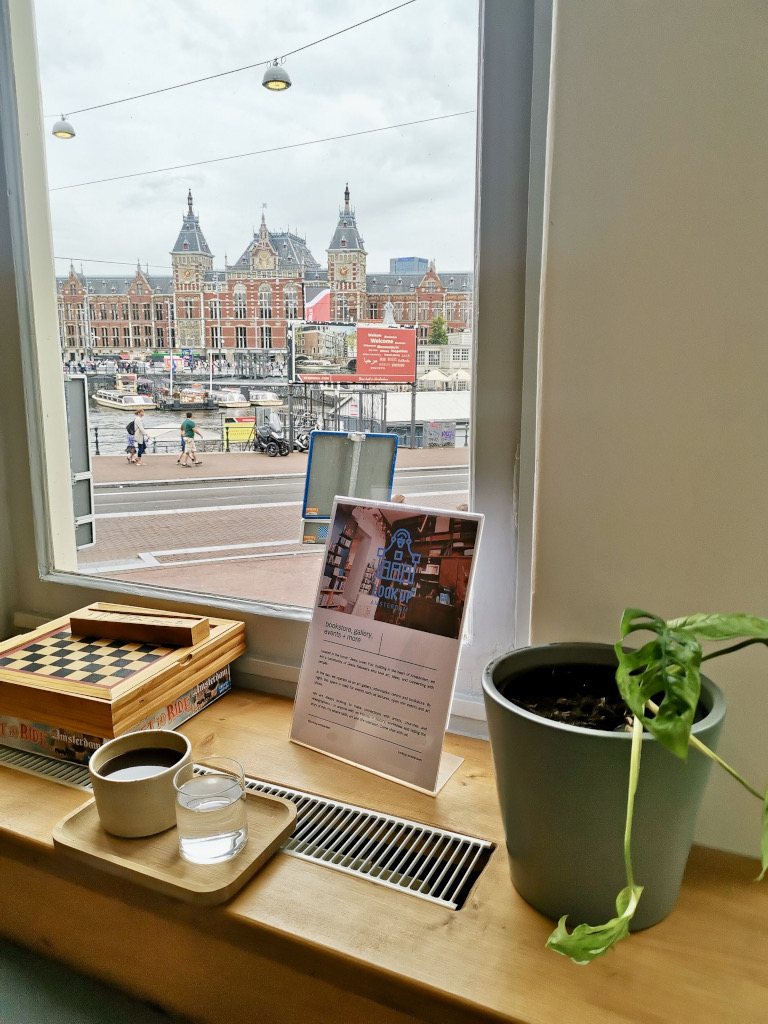 A coffee sitting on a window sill at priesthood cafe one of the best cafes in amsterdam