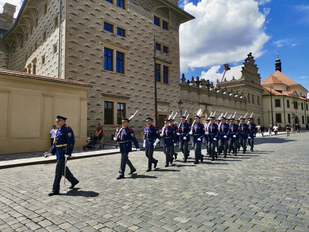 A group of soldiers marching down the road in Prague