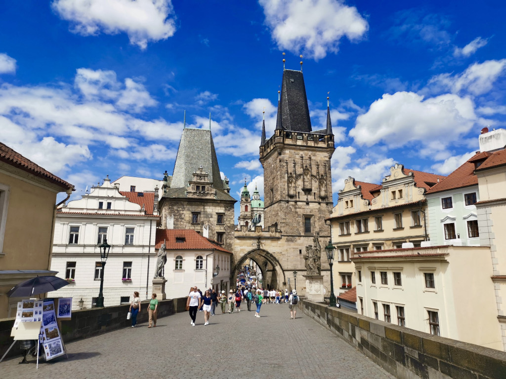 Tourists walking across the charles bridge to prague castle a great thing to do during a prague itinerary