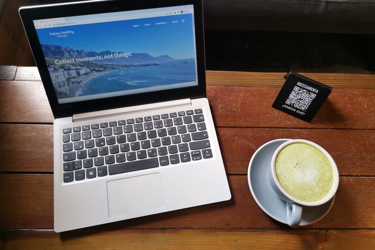 Laptop on a wooden table displaying the homepage of a travel blog that uses keyword monitoring to rank better in search results