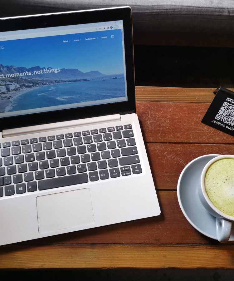 Laptop on a wooden table displaying the homepage of a travel blog that uses keyword monitoring to rank better in search results