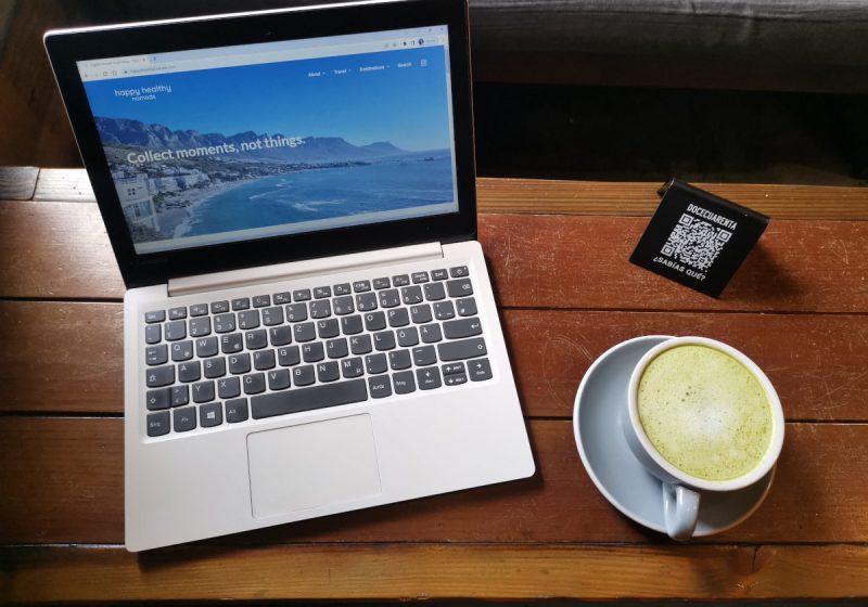 Laptop on a wooden table displaying the homepage of a travel blog that uses keyword monitoring to rank better in search results