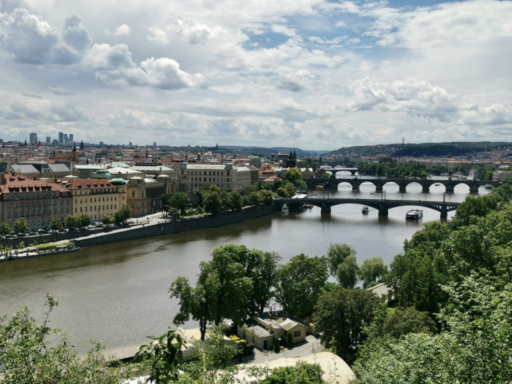 A view of three bridges over the river in prague from a hill top in Letna Park