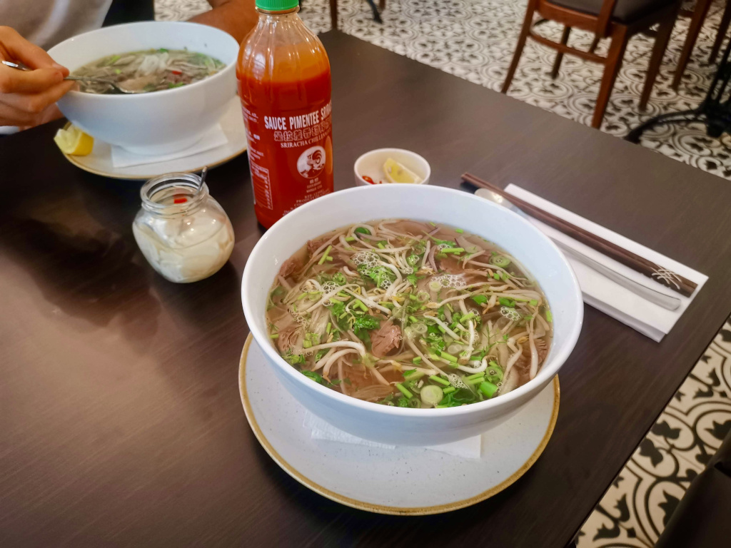 A bowl of pho sitting on a table at a vietnamese restaurant one of the best places to eat in prague