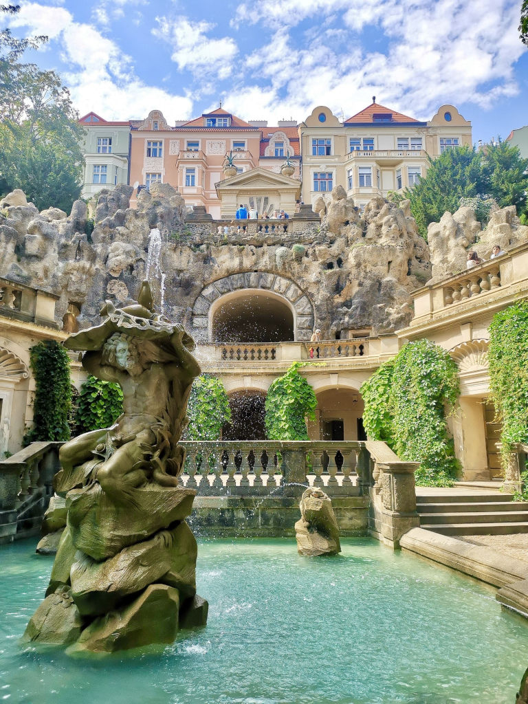 The grotto in prague with a fountain and a fake cave in the background