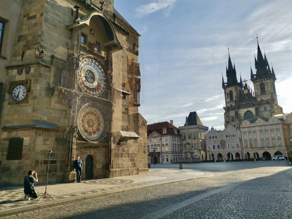 A man having his photo taken while wearing a suit at the old town main square in Prague