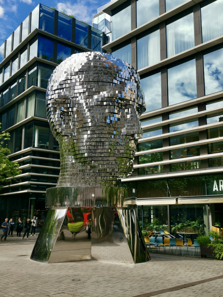 A rotating statue of a head that is made of sparkling blocks that move in certain patterns every hour