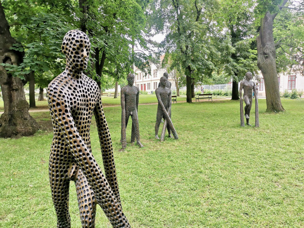 A group of creepy looking statues in a a park at a fortress in Prague