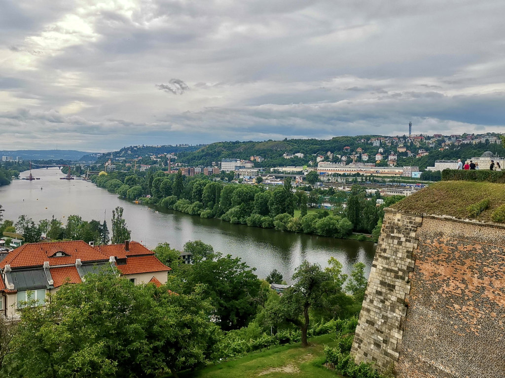 A group of tourists standing on the top of a wall at vysehard fortress a good place to stop on a prague itinerary