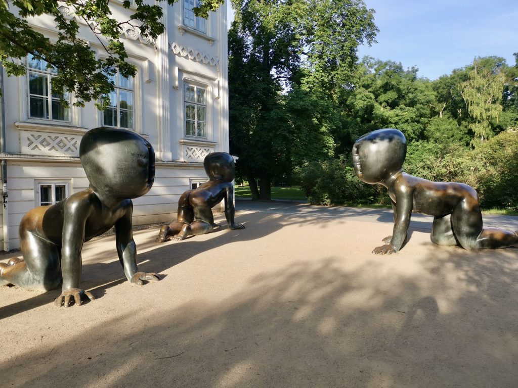 Three creepy looking baby statues in a park in Prague