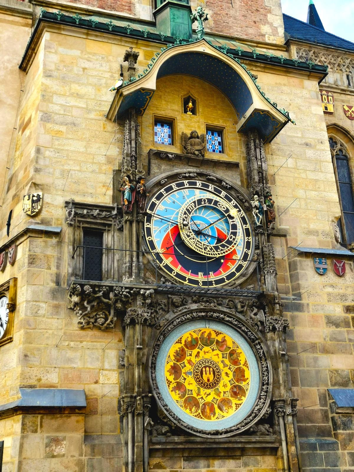 Close-up of Prague's medieval Astronomical Clock on the Old Town Hall, with blue, red and golden colored astronomical dials, moving figures of the Apostles, and a decorative calendar.