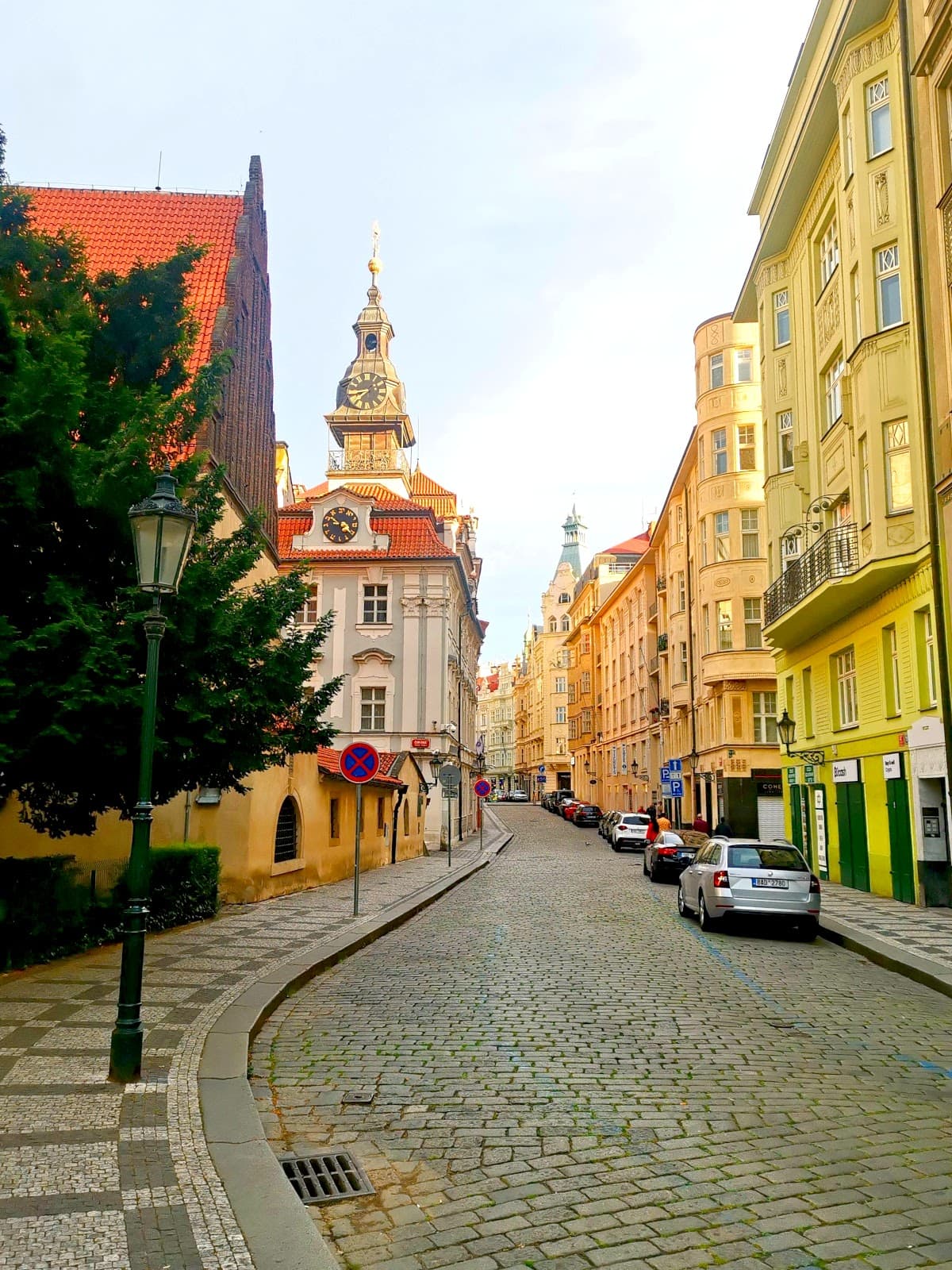 A cobblestone street with colorful  Art Nouveau buildings in the Jewish Quarter of Prague.