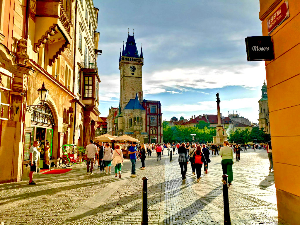 People strolling through Prague's Old Town Square toward the Town Hall tower, a must-see landmark on a 2-day Prague itinerary.