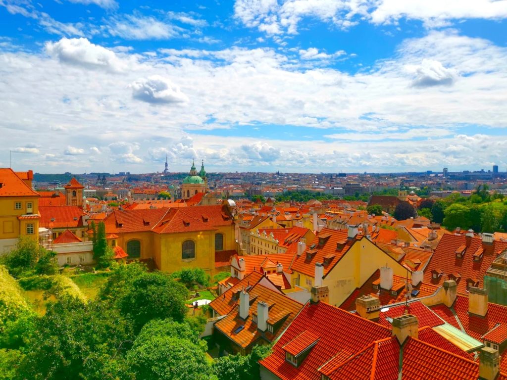 View over Malá Strana from Prague Castle overlooking red roofs and church towers.