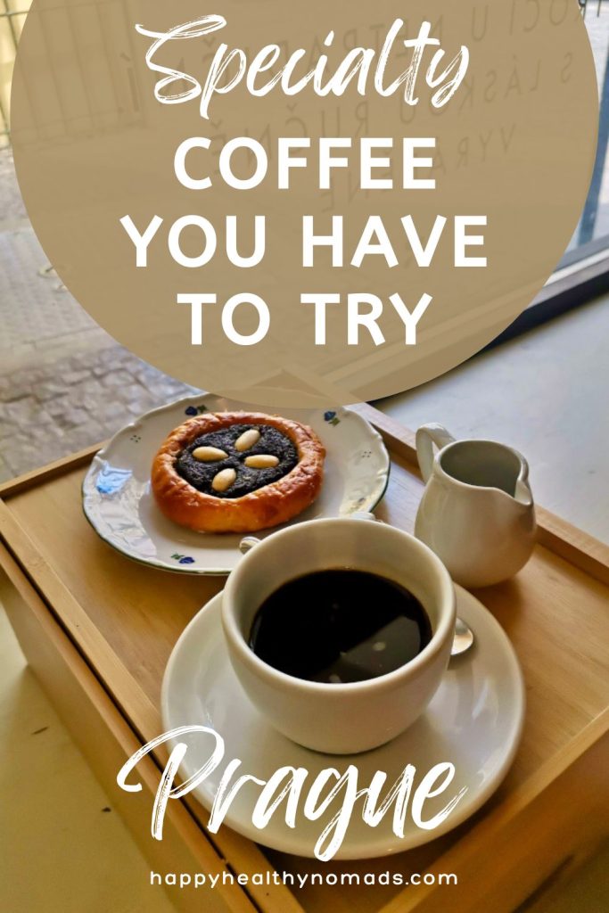 A white cup with black coffee next to a Czech pastry on a wooden tray with a text overlay saying "Specialty Coffee you have to try in Prague".