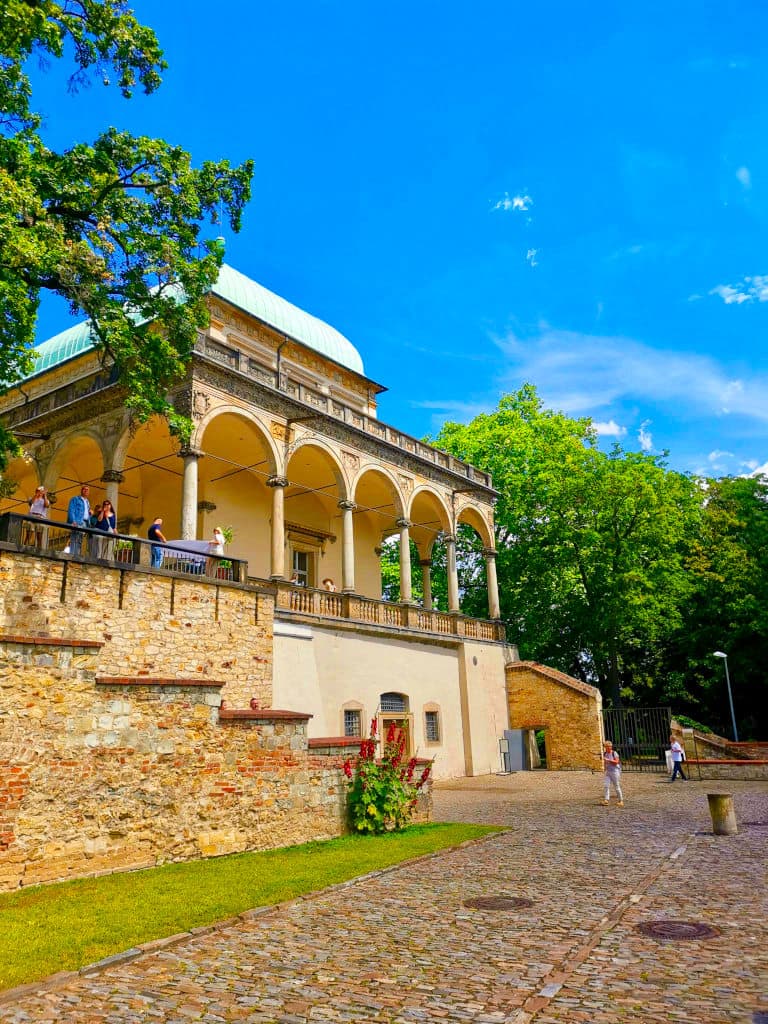 Queen Annes Summer Palace with round archways and tourists standing around it.