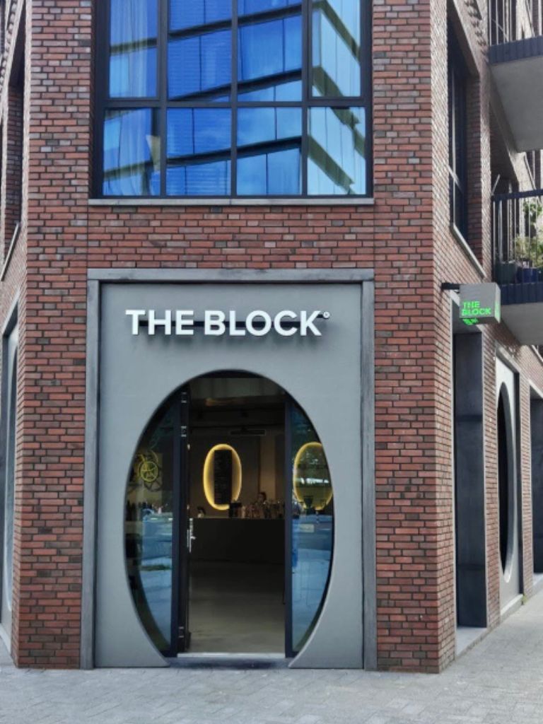 The futeristic and round entrance to the The Block Cafe in Amsterdam surrounded by a brick wall.