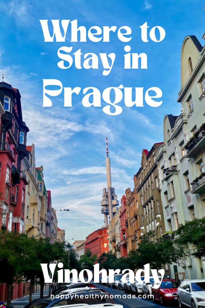 Street with houses and trees and Zizkov television tower in the distance with a text overlay saying "Where to Stay in Prague, Vinohrady".