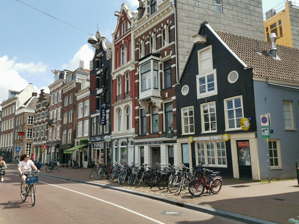 A woman riding a bike down a street in amsterdam