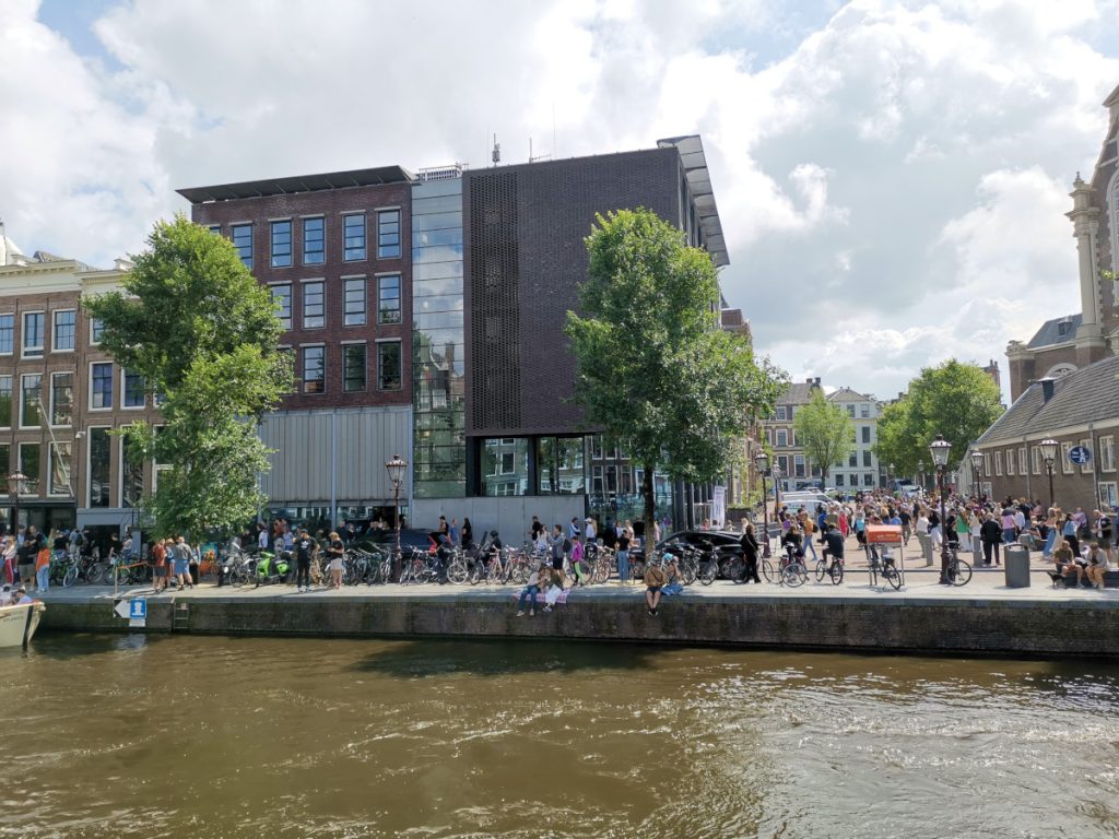 Tourists sitting outside of the Anne Frank House in Amsterdam