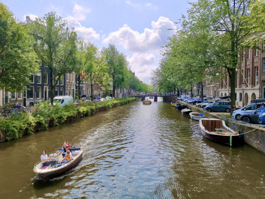 A boat crusing down a canal in the 9 de straatjes a great place to visit while in amsterdam