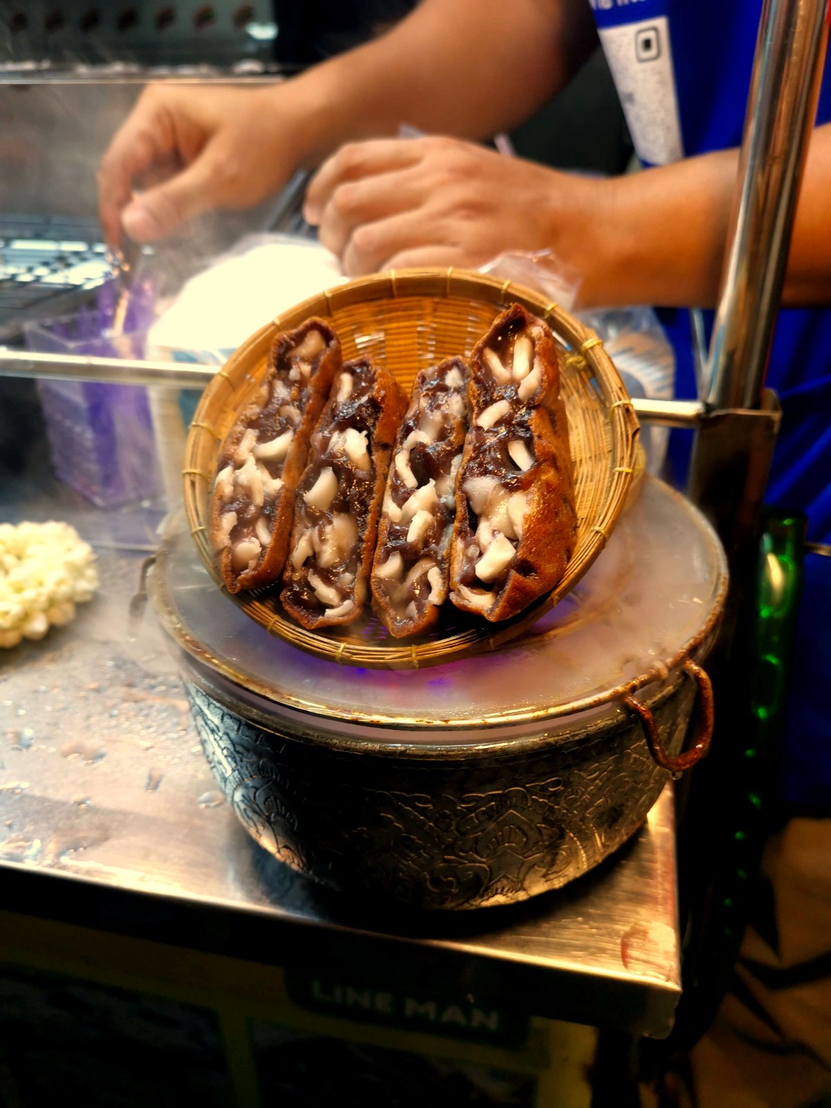 A bowl of soup on a metal table with pieces of pork in it called Kway Chap from Chinatown Bangkok.