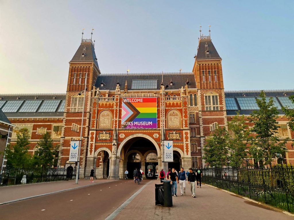 People waling along a footpath in front of the Rijksmuseum one of the best places to visit during an amsterdam itinerary