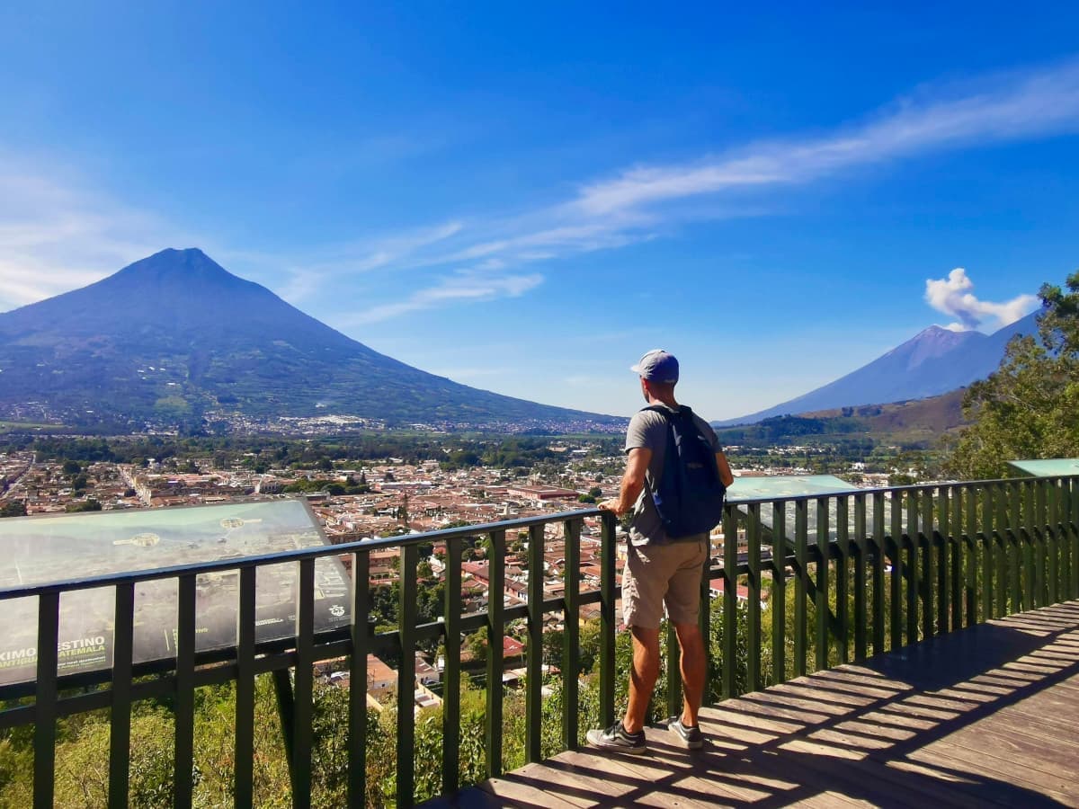 Allan gazes at two volcanoes in Antigua, Guatemala, one of our favorite budget-friendly and adventurous destinations in Latin America.