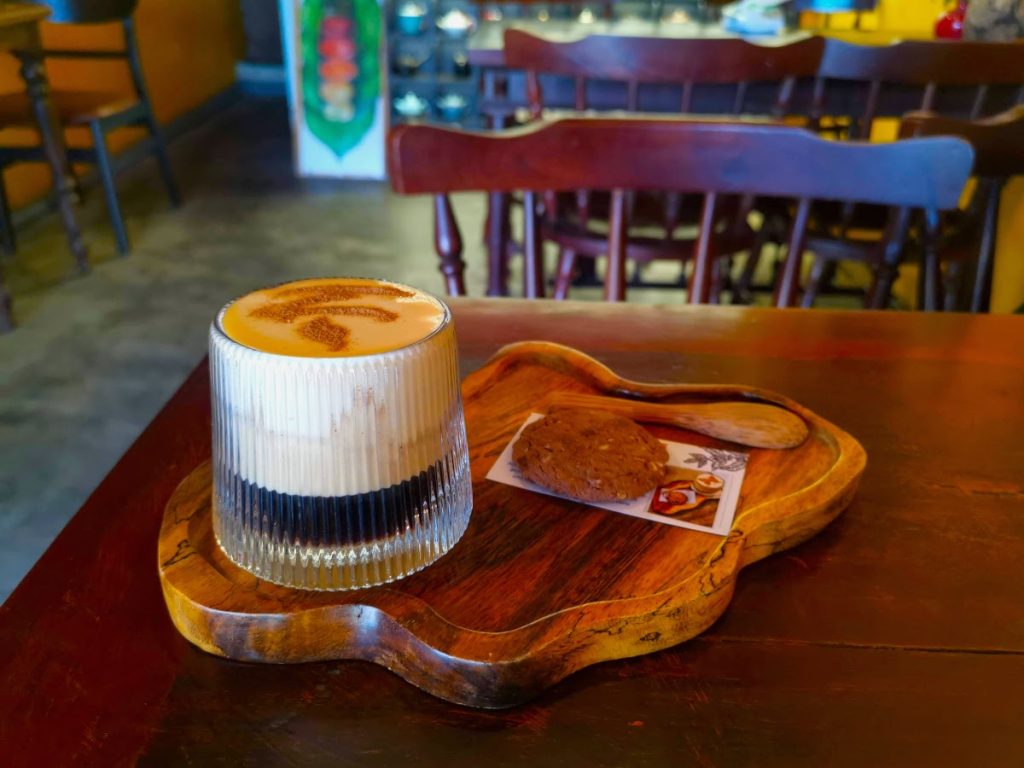 Creamy Vietnamese egg coffee on a wooden tray in one of the best Hoi An cafes.