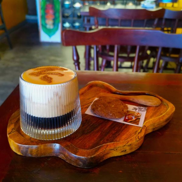 Creamy Vietnamese egg coffee on a wooden tray in one of the best Hoi An cafes.