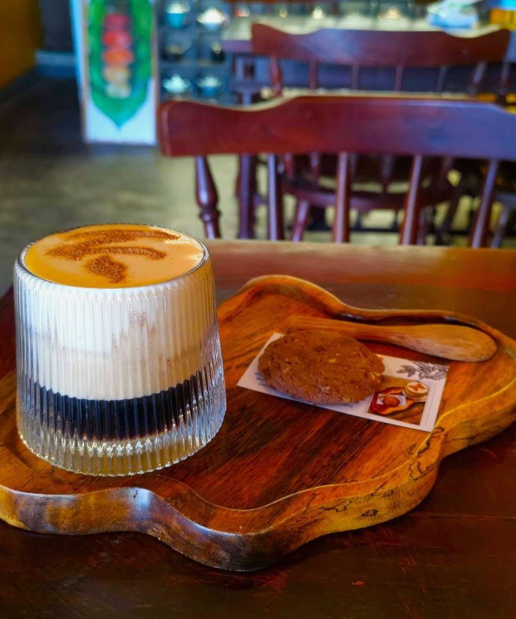 Creamy Vietnamese egg coffee on a wooden tray in one of the best Hoi An cafes.