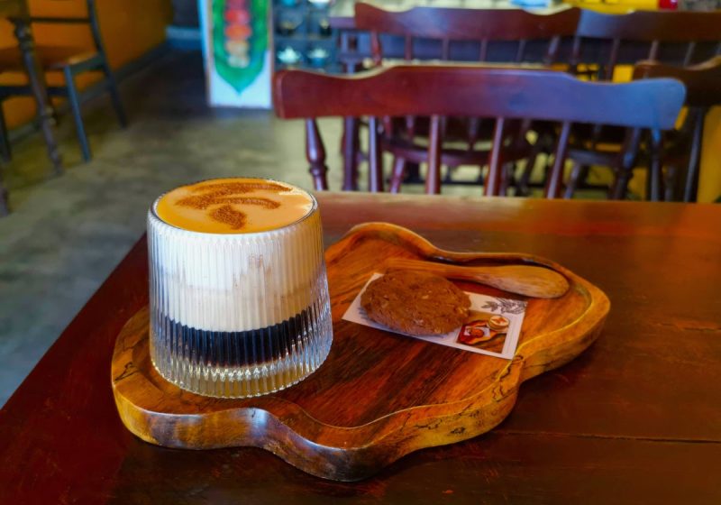 Creamy Vietnamese egg coffee on a wooden tray in one of the best Hoi An cafes.