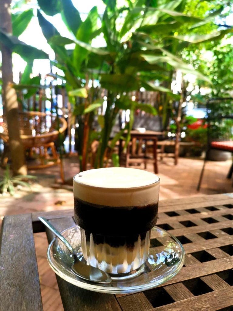 A glass filled with black coffee and a white dream at Good Eats, one of the best salt coffee Hoi An.